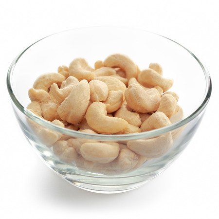 Glass bowl with cashew nuts isolated on white background.の写真素材