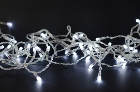 Christmas garland with lights on a black background.