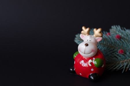 Figurine of a New Year's deer and a twig of a Christmas tree with red berries.の写真素材