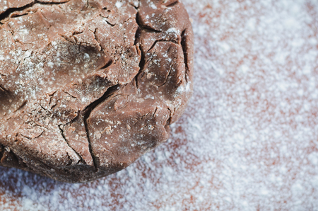 Chocolate dough for cakes on a wooden board, sprinkled with flourの写真素材