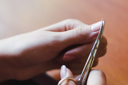 The process of nail clippingl scissors. Hand care concept. Soft focus.