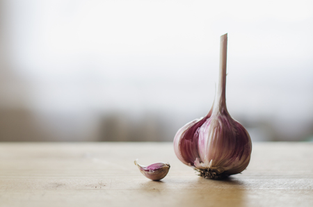 Head of garlic on a light wooden tableの写真素材