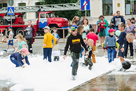 HORKI, BELARUS - JULY 25, 2018: Children of different ages play with white foam in the park at a party in the afternoon in a crowd of peopleのeditorial素材