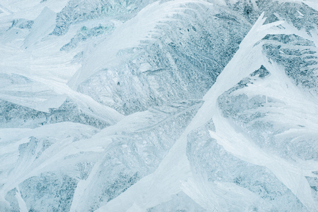 Frozen winter window tinted in blue color, texture, backgroundの写真素材