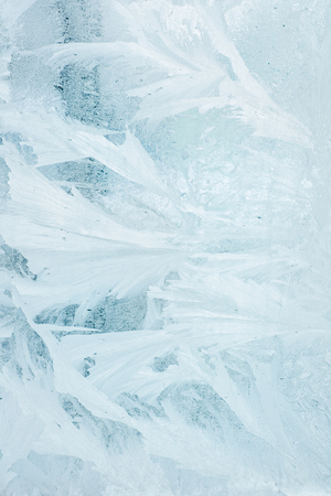 Frozen winter window tinted in blue color, texture, backgroundの写真素材