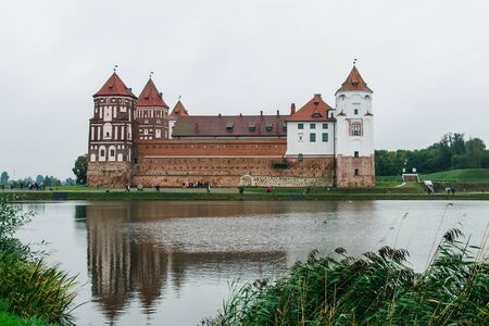 MIR, BELARUS - SEPTEMBER, 21, 2019: Mir Castle and its reflection in the lake on a cloudy autumn dayのeditorial素材