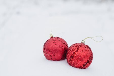 Two large red Christmas balls with decoration on white snowの写真素材