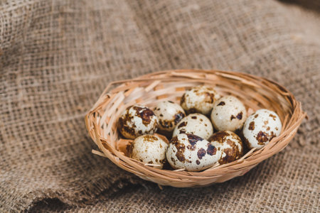 Quail eggs in a small homemade basket on a rough linen napkinの写真素材