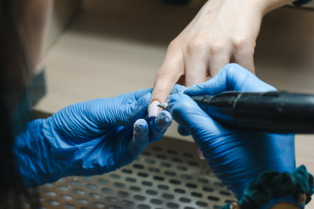 The manicurist removes the old gel from the nails using the hardware method closeupの写真素材