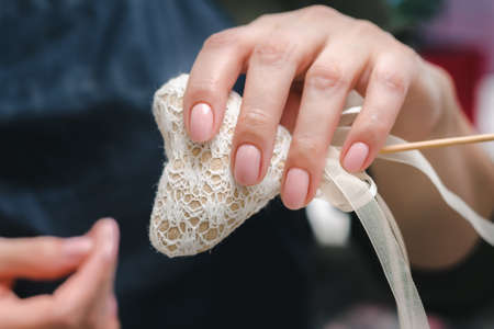 Well-groomed female hands with a beautiful pink manicure and a small homemade heart, close upの写真素材
