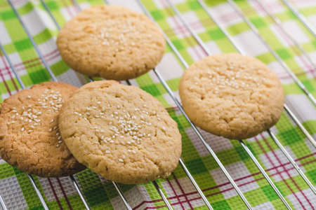 Homemade round shortbread cookies with sesame seeds on a wire rackの写真素材