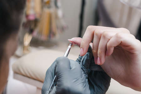 The process of leveling the gel coating on the client's nail plate close-upの写真素材
