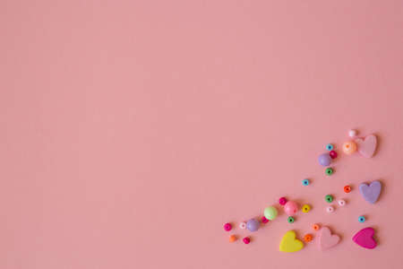 Template with place for text. Happy valentines day pink card with multicolored hearts. Multi-colored beads to create jewelry and bijouterieの写真素材