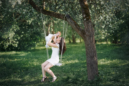 Happy childhood of a healthy child. Close-up baby in mother's arms. Mom pressed against the forehead of your baby. Tender relationship between baby and motherの写真素材