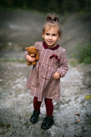 Little girl holding a teddy bear. Portrait of a little girlの写真素材