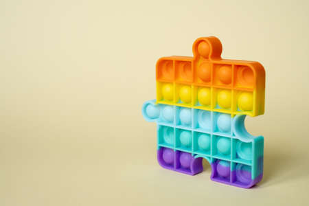 Popular silicone colorful multicolored anti-stress popit toy for baby on yellow background. simple dimple. Pop it toy. A toy in the form of a puzzleの写真素材