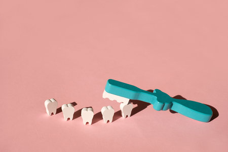 A toy toothbrush brushes teeth on a pink background. The concept of dental hygienic dental care....