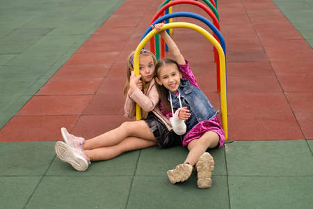Joy little preschool girl with broken arm and cast on her forearm having fun at children's sports...