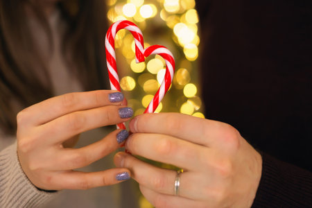 A married man with a mistress holds two lollipops in his hand, folding them in the shape of a heart....