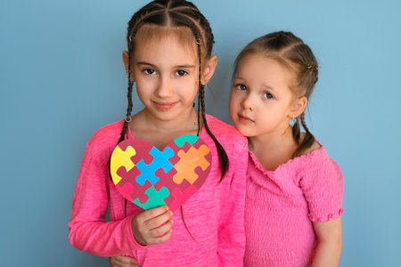 Preschoolers made a greeting card as a sign of support for children with autism syndrome. A heart with colorful puzzle pieces is a symbol of autism.の写真素材