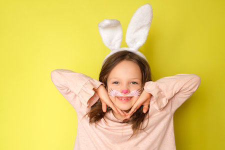 A playful girl dressed up as an Easter bunny shows off her makeupの写真素材