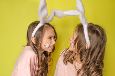 Two girls dressed up as Easter bunnies having fun together. Laughter and childish happiness