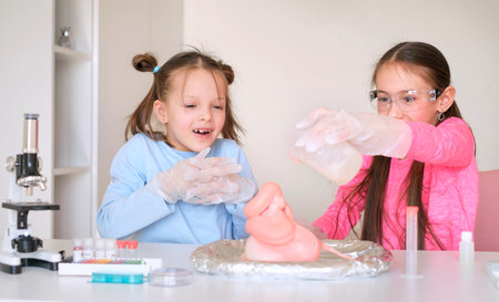 Children conduct an experiment with the eruption of a foam volcanoの写真素材