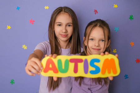 The children made a sign with the description autism, demonstrating support, mercy and tolerance for people suffering from autism disorder spectrumの写真素材