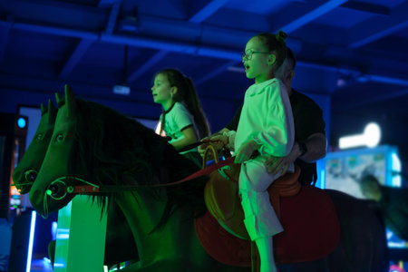 Kids and dad ride an interactive horse in an amusement park