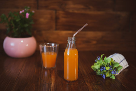 Fresh juice in bottle on wooden tableの写真素材