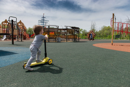 boy on the playground riding a scooterの写真素材