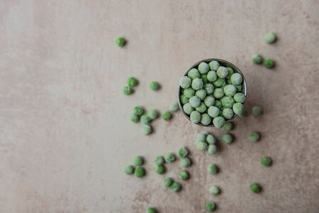 Small bucket with frozen young green peas