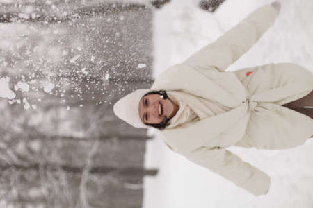 Two girls playing snowballs in the snow in the winter in a warm winter clothesの写真素材