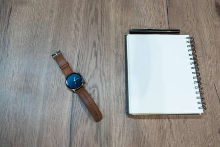 classic smart watch on a rustic table with space for text on white notebook