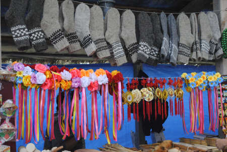 Warm socks and various national hair bands hanging on a clothesline at a flea market at the Sorochin Fairの写真素材