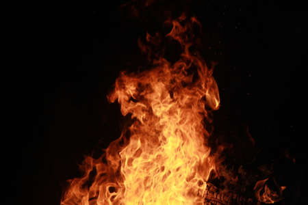 Realistic effect of isolated fire on a black background. The concept of particles, sparkles, flame...