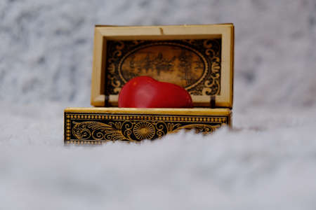 Jewelry box with a heart inside. Painted wooden box for decoration. Soft fluffy background. For newlyweds, a marriage proposal. February 14, valentine. Love, decor.の写真素材