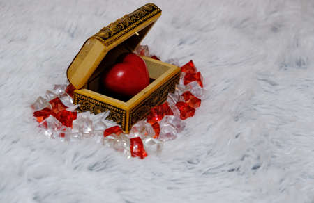 Jewelry box with a heart inside. Painted wooden box for decoration. Soft fluffy background. For newlyweds, a marriage proposal. February 14, valentine. Love, decor.の写真素材