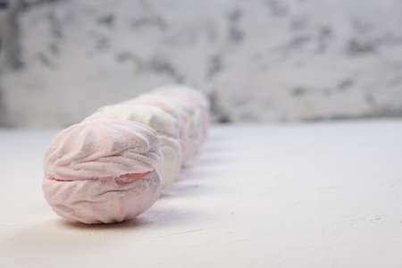Marshmallow without packaging close-up on a white background. side view. Zephyr pink and white....