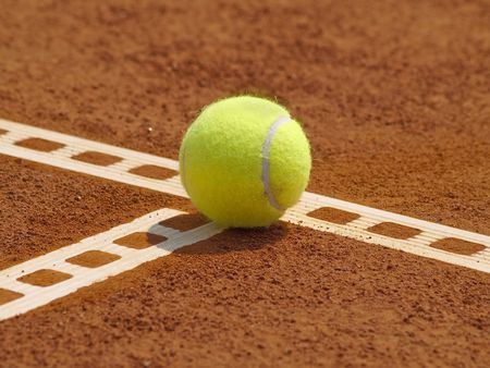 Detail of clay court with tennis ball on the lineの写真素材