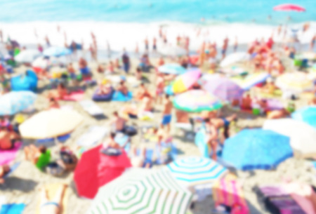 crowded beach background with unrecognizable people with intentional blur effectの写真素材