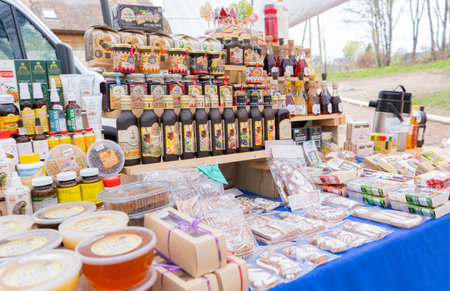 Izborsk, Russia, April 30 2023. Market stall displaying a bunch of stacked colorful herbal drinks, honey, local gingerbreads. Shopping malls near the fortress. Souvenirs and gifts.のeditorial素材