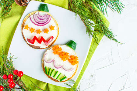 Christmas pancake breakfast shaped tree ornaments with fresh vegetables: pepper, onion, cucumber, carrot, pumpkin. Flatly. Christmas fun food for kids, funny breakfast idea healthy food, dietの写真素材