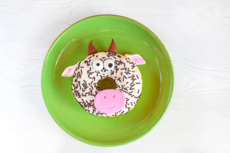 A bull donut - with the symbol of the new year of 2021. Christmas fun food for kids party or for breakfast. New year's, xmas concept 2021. Beautiful and delicious cakes themed treat. Christmas food bull.の写真素材