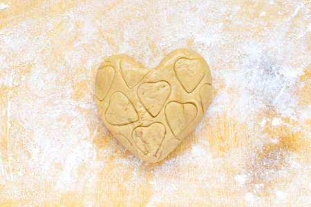 Valentine's day, Christmas food. Heart shaped gingerbread cookie dough on a rolling board. Homemade food.の写真素材