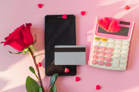 Valentine Day online Shopping. Credit card, smartphone, calculator, red rose, red hearts. Seasonal Holiday sale. Romantic shopping for wedding, women's day, buying gifts Valentine's Day for lovers.の写真素材