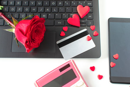 Valentine Day online Shopping. Laptop, calculator, credit card, red rose, red hearts. Romantic shopping for wedding, women's day, buying gifts Valentine's Day for lovers. Seasonal Holiday sale.の写真素材