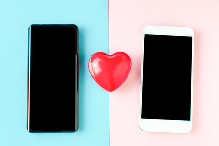 Valentines Day Coronavirus two phones and a heart. Covid 19 Valentine. Online communication, virtual love, loneliness web Internet, love texting, messaging, online dating. St. Valentines day conceptの写真素材