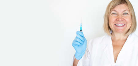 Adult doctor, nurse, infectious disease scientist hand in blue protective gloves holds the flu, measles, vaccination, prepares for vaccination. Medicine and conceptの写真素材