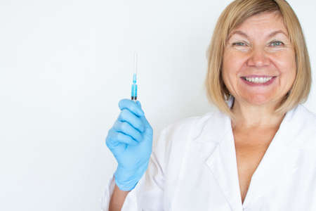 Adult doctor, nurse, infectious disease scientist hand in blue protective gloves holds the flu, measles, vaccination, prepares for vaccination. Medicine and conceptの写真素材